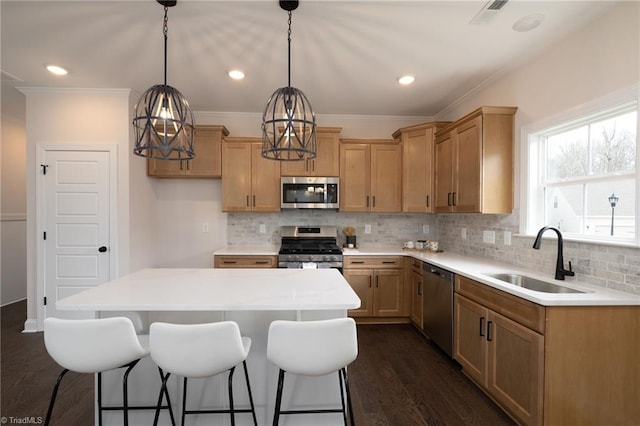 kitchen featuring a center island, stainless steel appliances, tasteful backsplash, dark wood-type flooring, and a sink