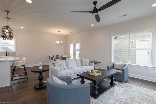 living room featuring baseboards, visible vents, dark wood finished floors, and recessed lighting