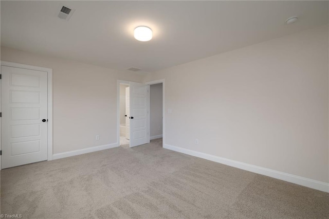 unfurnished room featuring carpet flooring, visible vents, and baseboards