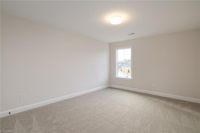 empty room with light carpet, visible vents, and baseboards