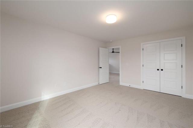 unfurnished bedroom with a closet, carpet flooring, and baseboards