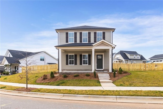 view of front of home featuring a front yard, covered porch, and fence