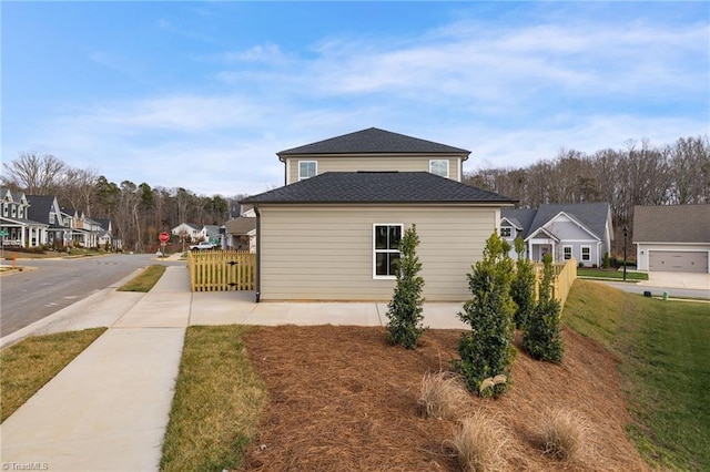 view of home's exterior with a shingled roof, a residential view, and a lawn