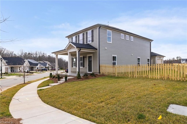 view of property exterior featuring a residential view, fence, a porch, and a lawn