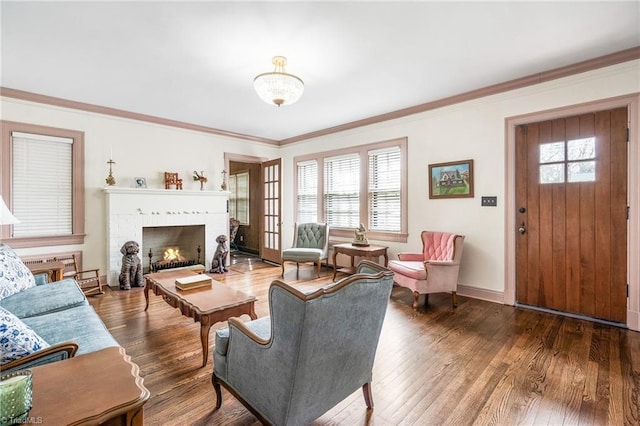 living area with ornamental molding, wood finished floors, and a wealth of natural light