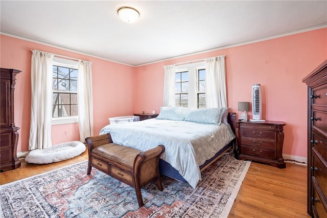 bedroom with multiple windows, light wood-style flooring, and crown molding