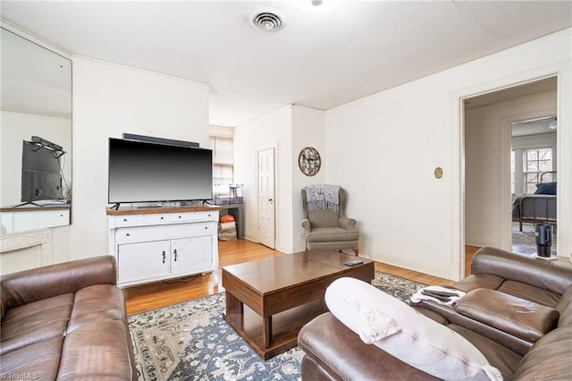 living room with baseboards, visible vents, and light wood finished floors