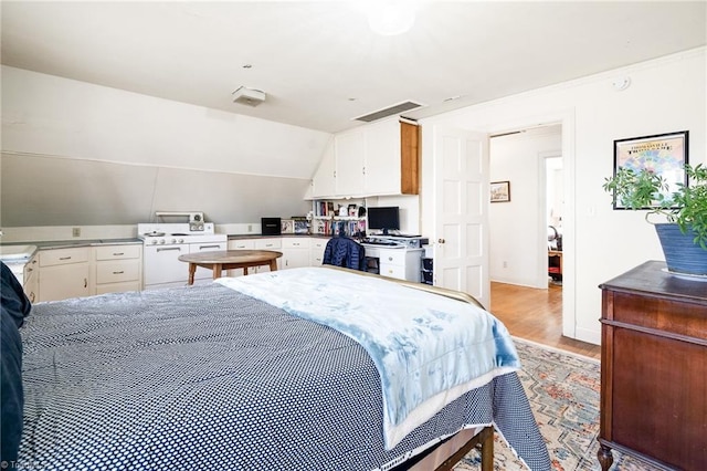 bedroom featuring visible vents, vaulted ceiling, and light wood finished floors