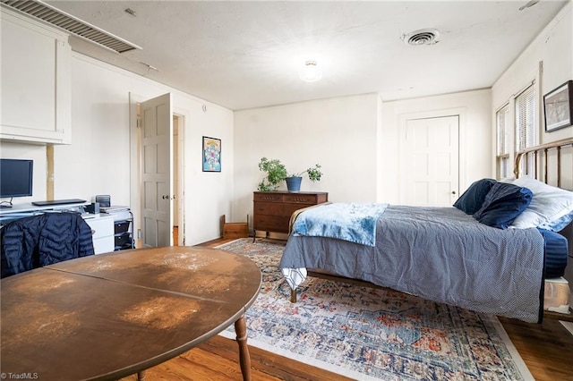 bedroom featuring visible vents and wood finished floors