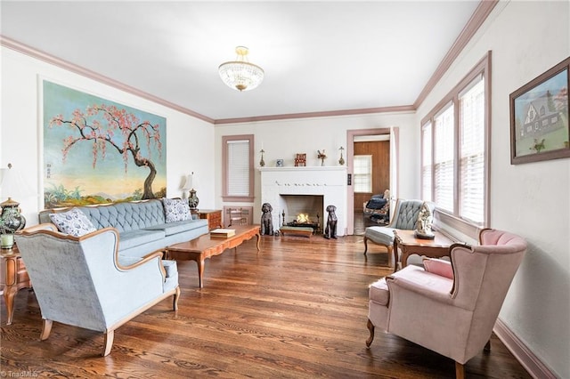 living area featuring baseboards, a lit fireplace, wood finished floors, and crown molding