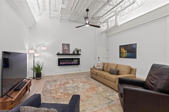 215 S Jefferson Ave Unit 102, West Jefferson, NC 28694 - living room with a towering ceiling, a ceiling fan, wood finished floors, and a glass covered fireplace