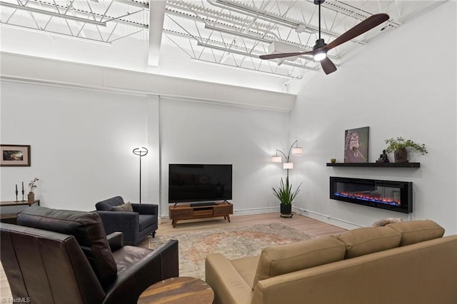 215 S Jefferson Ave Unit 102, West Jefferson, NC 28694 - living room featuring wood finished floors, ceiling fan, a high ceiling, and a glass covered fireplace