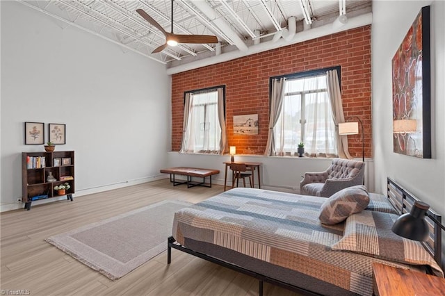 215 S Jefferson Ave Unit 102, West Jefferson, NC 28694 - bedroom with wood finished floors, brick wall, and ceiling fan