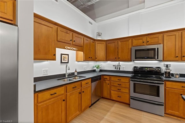 215 S Jefferson Ave Unit 102, West Jefferson, NC 28694 - kitchen with stainless steel appliances, dark countertops, brown cabinetry, light wood-style flooring, and a high ceiling