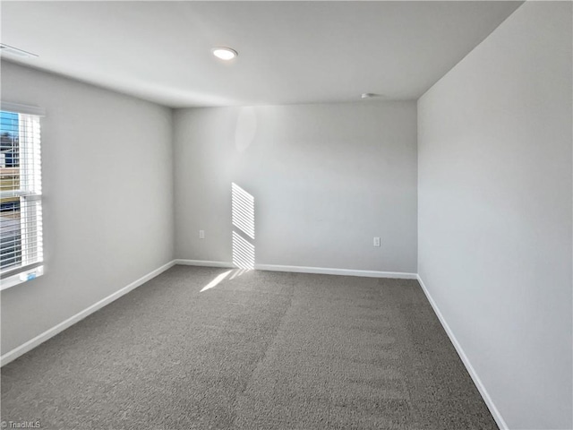 carpeted spare room with visible vents and baseboards