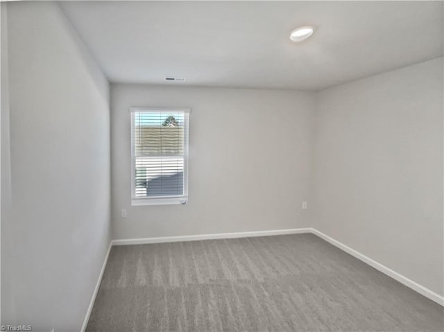 spare room with carpet and baseboards