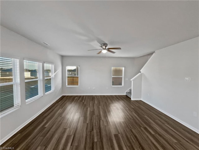 unfurnished living room with stairs, ceiling fan, dark wood finished floors, and baseboards