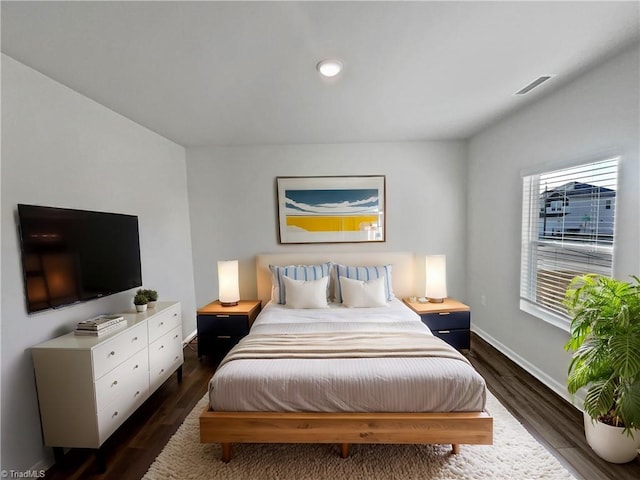 bedroom with dark wood-type flooring, visible vents, and baseboards