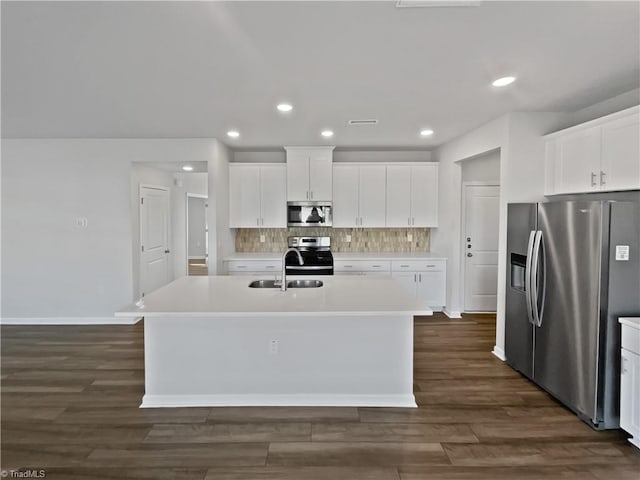 kitchen featuring white cabinets, a kitchen island with sink, stainless steel appliances, and light countertops