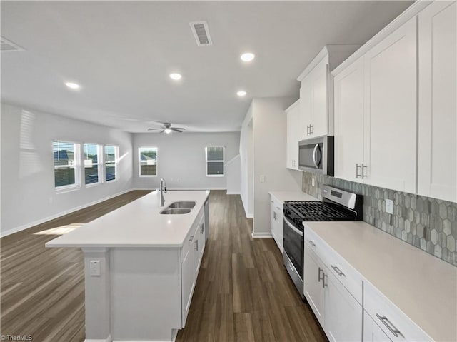 kitchen with an island with sink, white cabinetry, appliances with stainless steel finishes, and light countertops