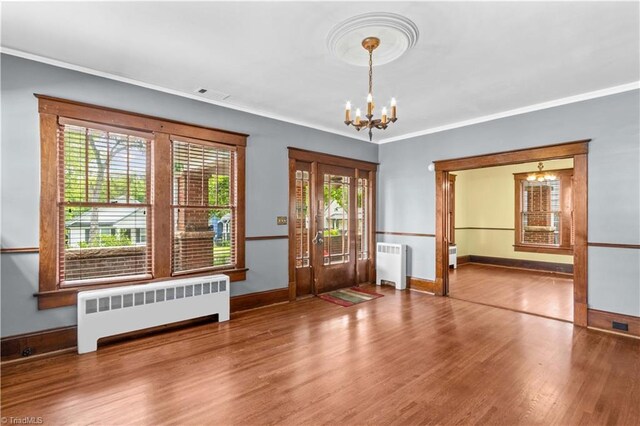 119 Wiley Ave, Salisbury, NC 28144 - foyer featuring radiator heating unit, a chandelier, wood finished floors, baseboards, and crown molding