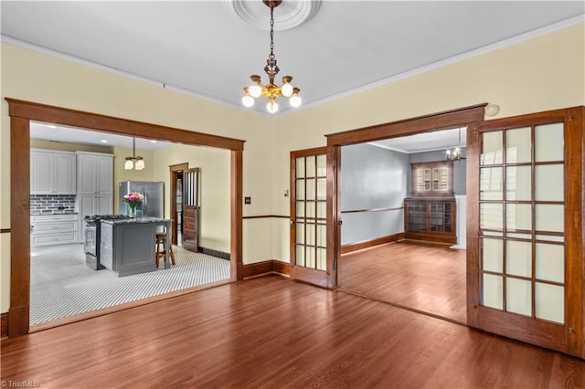 119 Wiley Ave, Salisbury, NC 28144 - unfurnished dining area featuring a chandelier, wood finished floors, crown molding, baseboards, and french doors