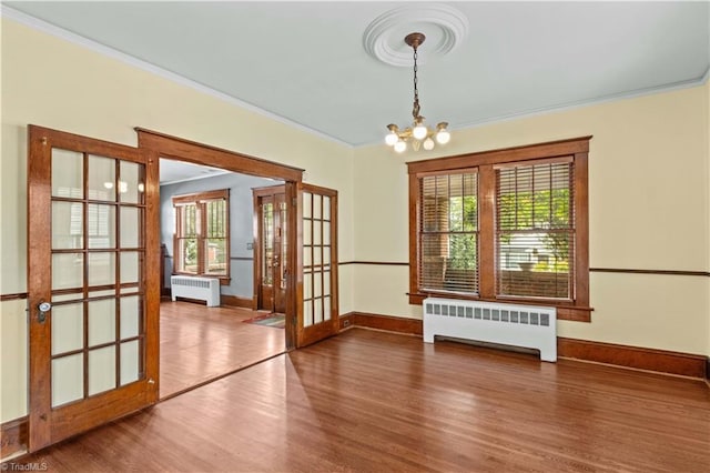 119 Wiley Ave, Salisbury, NC 28144 - unfurnished dining area featuring radiator, wood finished floors, ornamental molding, a chandelier, and french doors