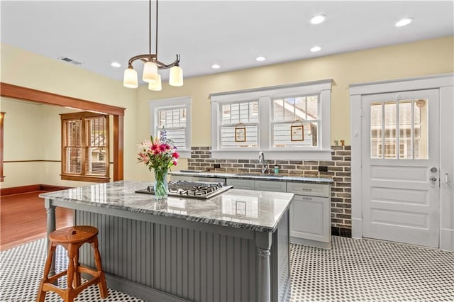119 Wiley Ave, Salisbury, NC 28144 - kitchen featuring a sink, stainless steel gas cooktop, a chandelier, a kitchen bar, and light stone countertops