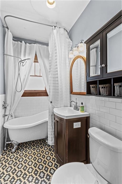 119 Wiley Ave, Salisbury, NC 28144 - full bathroom with tile walls, toilet, vanity, a wainscoted wall, and tile patterned floors