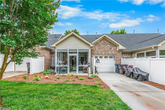 1627 Crestlawn Trl, Pfafftown, NC 27040 - view of front facade with a sunroom, brick siding, an attached garage, driveway, and a shingled roof