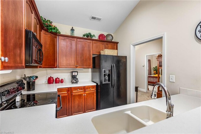1627 Crestlawn Trl, Pfafftown, NC 27040 - kitchen with black appliances, vaulted ceiling, a sink, light countertops, and light carpet