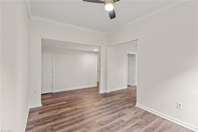 unfurnished room with hardwood / wood-style floors, ceiling fan, and crown molding