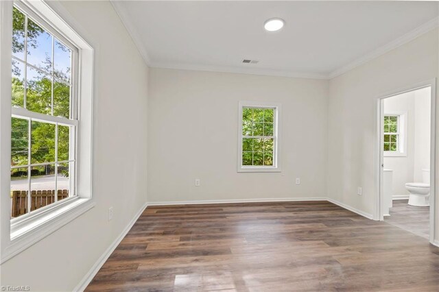 unfurnished room featuring plenty of natural light, dark hardwood / wood-style flooring, and crown molding