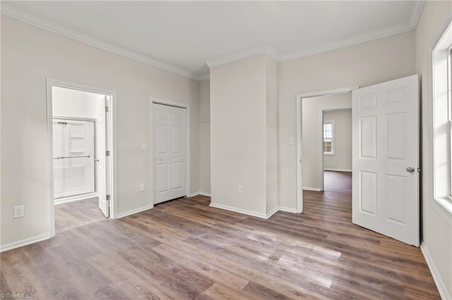 unfurnished bedroom with crown molding, ensuite bath, and hardwood / wood-style floors