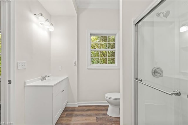 bathroom with an enclosed shower, toilet, hardwood / wood-style flooring, and vanity