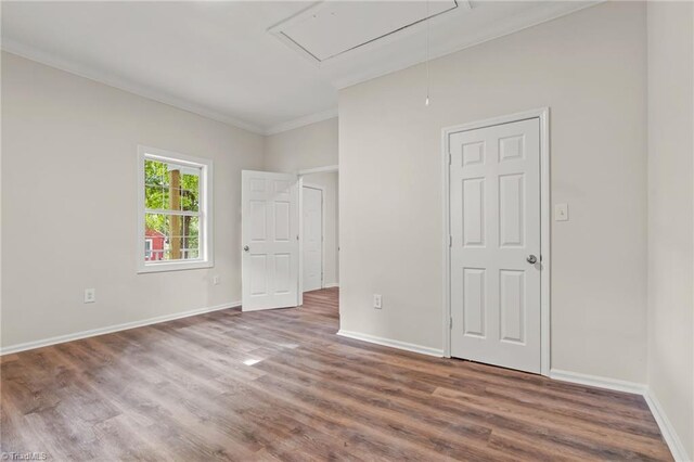 unfurnished bedroom with ornamental molding and hardwood / wood-style flooring