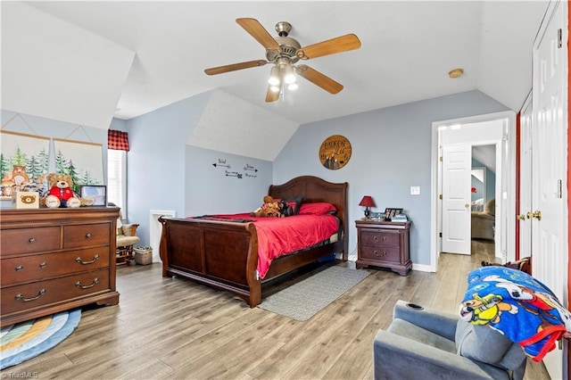 bedroom with a ceiling fan, baseboards, vaulted ceiling, and light wood finished floors