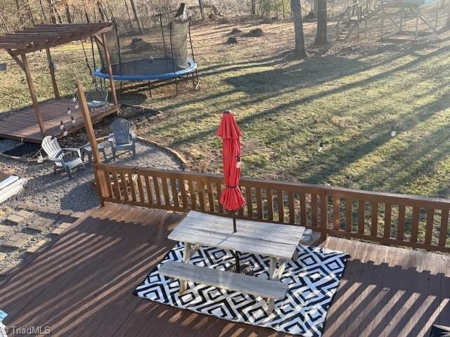 wooden deck with a trampoline and outdoor dining area