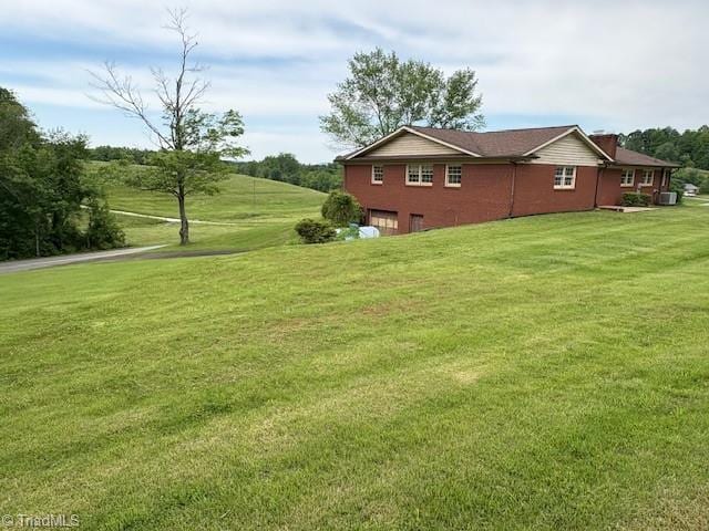 view of home's exterior featuring an attached garage and a lawn