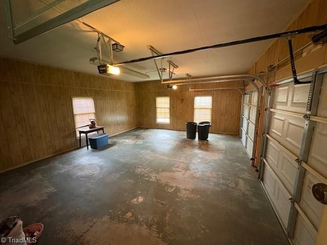 garage with a garage door opener and wood walls