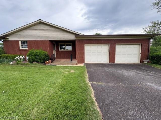 ranch-style house featuring driveway, an attached garage, a front yard, and brick siding