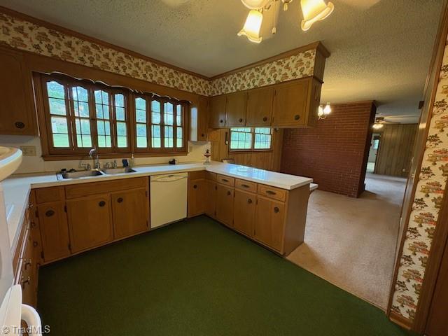 kitchen with white dishwasher, a sink, a textured ceiling, light countertops, and carpet floors