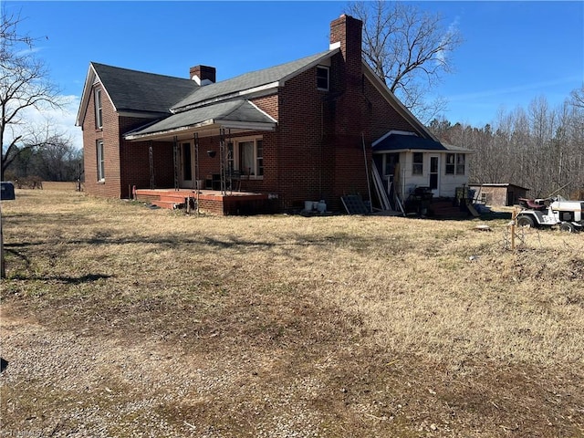 view of side of home featuring brick siding and a chimney