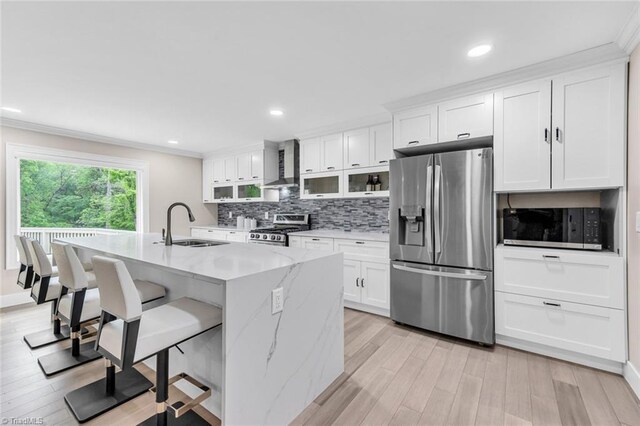 104 Shawnee Cir, Lexington, NC 27295 - kitchen with an island with sink, wall chimney range hood, white cabinets, a sink, and stainless steel appliances