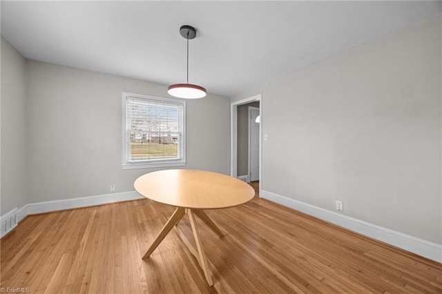 unfurnished dining area featuring light wood-style flooring and baseboards