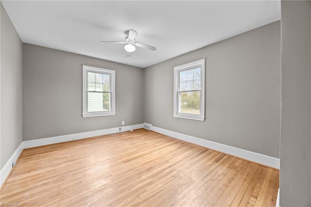 unfurnished room with light wood-type flooring, plenty of natural light, baseboards, and a ceiling fan