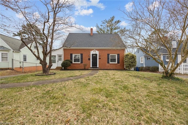 view of front of property with a front lawn, fence, a shingled roof, brick siding, and a chimney