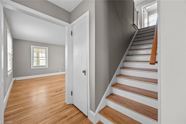 stairway with wood finished floors and baseboards