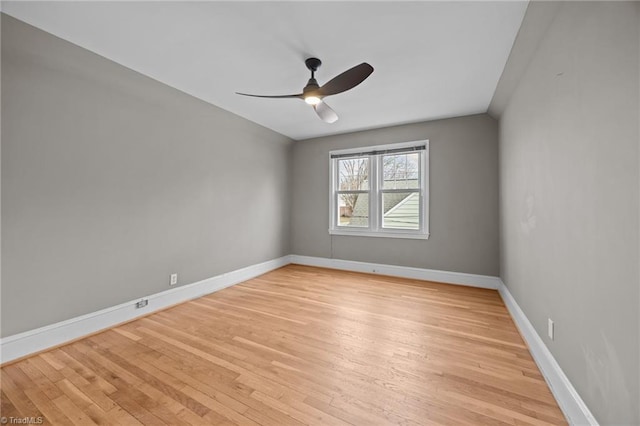 empty room featuring ceiling fan, baseboards, and light wood-style floors