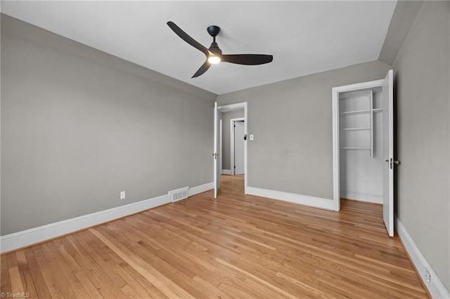 unfurnished bedroom featuring a ceiling fan, baseboards, visible vents, light wood-style flooring, and a closet